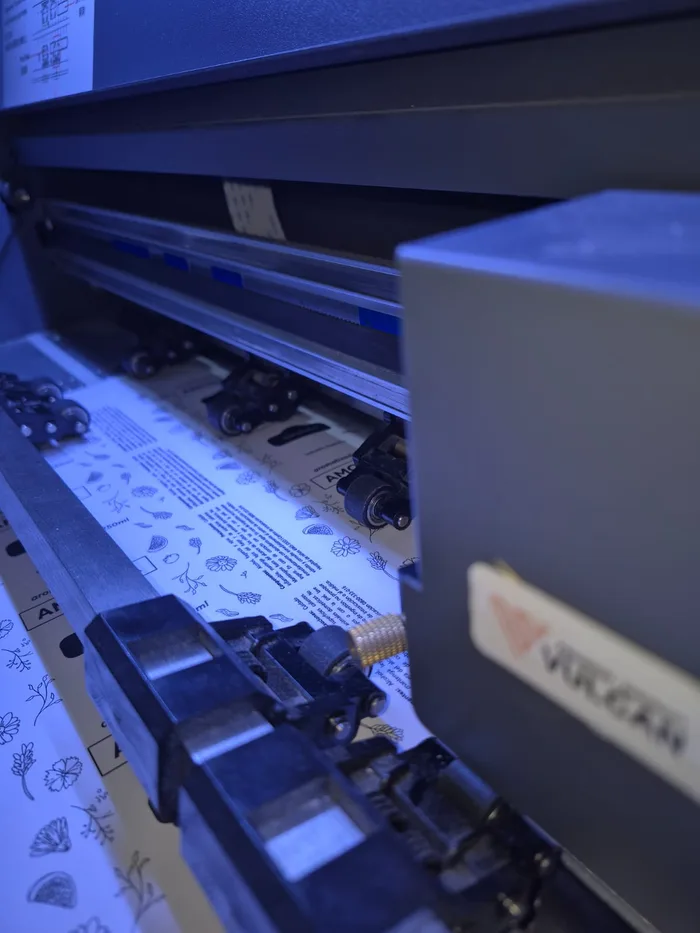 Plotter de corte trabajando sobre un pliego de stickers en el taller de Chido Gráfica, CABA