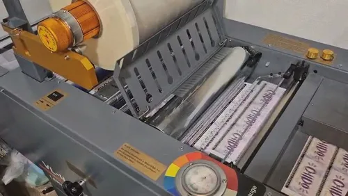 Laminadora del taller pasando pliegos impresos