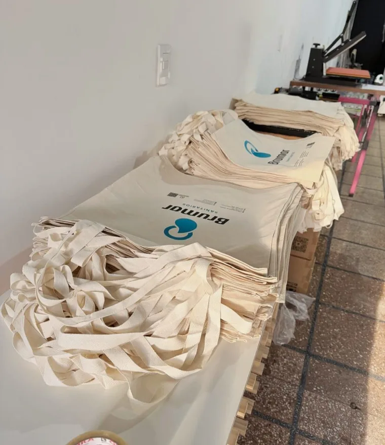 Pila de totebags de lienzo impresas con el logo de un cliente