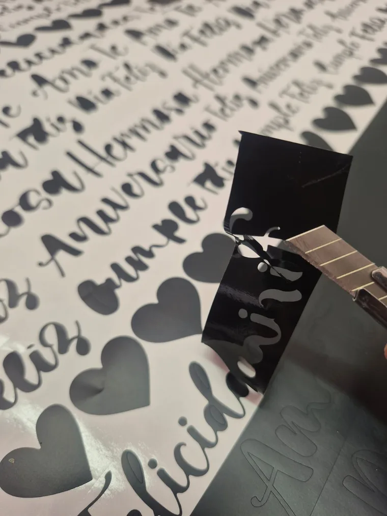 Letras y calcos de vinilo de corte negro sobre un pliego